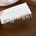 Detailed view of silver-toned geometric earring set featuring sparkling rhinestones - Silver Earring Post Style / 12-Piece Set / Silver