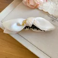 Detailansicht der cremefarbenen Satin-Schleife-Banane-Haarklammer mit elegantem Knoten - Weiß