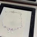 Detailed view of silver bow-knot bracelet with pink sparkling cubic zirconia stones. - Silver-Pink
