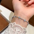 Detailed view of an elegant silver bracelet with zircon flowers and turquoise beads on wrist - Flower Bracelet / Blue