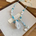 Ocean themed beaded necklace with white shell pendant and blue starfish charms. - Silver-Blue