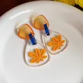 Primer plano detallado de pendientes de acetato con estampado de hoja de arce y azul - Poste de Plata Estilo Triángulo Estampado / Amarillo