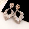 Close-up detail of silver-tone metal pleated leaf earrings with hammered texture and hollow design - Silver (Silver Pin)