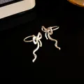 Elegant silver bowknot ear cuffs with flowing wavy tassel design for non-pierced ears - Bowknot Style (HE32670) / Silver