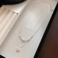 Elegante collar de doble capa de plata con perlas blancas y detalle de colgante de estrella - Estilo de Doble Capa / Plateado