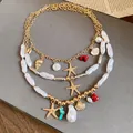 Detailed view of triple-layered vacation necklace with pearls and starfish charms - Gold, Silver and White
