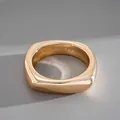 Gros plan d'un bracelet jonc géométrique minimaliste au fini doré poli et brillant. - Carré Or