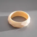Gros plan détaillé d'un bracelet jonc en acrylique crème à facettes géométriques - Blanc