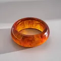 Gros plan détaillé d'un bracelet en acrylique ambré marbré avec effets d'ombre et lumière - Marron