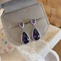Macro detail of elegant purple teardrop zircon earrings with exquisite micro-pave setting - Purple