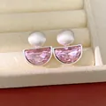 Dettaglio di eleganti orecchini a clip semicircolari in cristallo rosa e argento opaco. - Argento