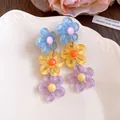 Close-up of colorful dopamine style tiered resin daisy flower drop earrings for women - Contrast (Blue-Yellow-Purple)