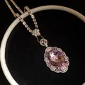 Close-up of elegant oval pink gemstone pendant necklace with shimmering crystals. - Silver-Pink
