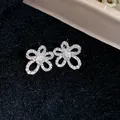 Detailed macro shot of elegant silver flower stud earrings adorned with sparkling zircons - Flower (HE31339) / Silver