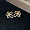 Detailed close-up showing the sparkling zircon petals of these 18k gold plated flower stud earrings - Flower (HE31339) / Gold