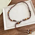 Detail view of bohemian braided waist chain with colorful wooden beads on a white tray. - Braided Waist Chain / 157cm Length / Brown