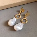 Eleganti orecchini pendenti d'oro con perle barocche su sfondo minimalista - Pendente Perla Barocca (HE33242) / Oro-Bianco