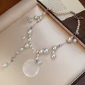 Detail shot showing the glossy pearls and shell pendant of this elegant necklace - Pearl Shell Tassel Necklace / White/Silver