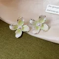 Vista detallada de elegantes pendientes de flores de esmalte estilo francés con perla - Verde