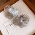 Vue détaillée d'élégantes boucles d'oreilles fleurs en métal argenté avec perle et clip. - Clip Argent Large / Argent