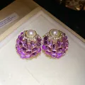 Primer plano de pendientes vintage con gemas moradas y perlas en su caja de regalo. - Púrpura