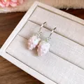 Detailed close-up of cute pink drip oil strawberry pendant earrings on a jewelry box. - Light Pink
