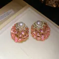 Detalle de pendientes vintage con piedras rosas, perla blanca y brillantes en caja beige - Rosa