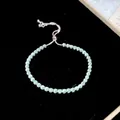Primo piano di un bracciale bolo regolabile in zircone con pietre azzurre su velluto nero - Verde Pallido