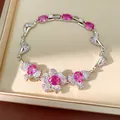 Elegante Nahaufnahme eines versilberten Armbands mit pinkfarbenen Zirkonia-Blütensteinen. - Blumenarmband / Silber-Rosa