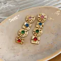 Close-up of vintage geometric earrings with colorful rhinestones in gold-tone metal plating. - Silver Earring Post Style / Gold Multicolor