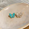 Close-up detail of asymmetric butterfly stud earrings with pavé zircon and turquoise resin - Asymmetric Butterfly Stud Earrings / Gold (Blue Wings)
