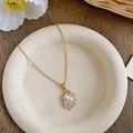 Detail of 18k gold plated feather necklace with zircon and mother of pearl inlay - Gold