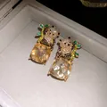 Detail shot of panda-shaped silver stud earrings with square-cut champagne gems - Champagne