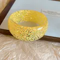 Detail shot of a yellow resin bangle bracelet with colorful sparkles, dopamine style - Yellow