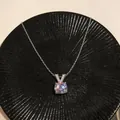 Vista dettagliata di un ciondolo a V in argento con zircone scintillante su vassoio nero - Ciondolo Tondo a Forma di V Bianco / Argento