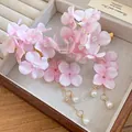 Detailed close-up view of elegant pink fabric flower hair clips with hanging pearl tassels - Pink
