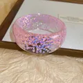 Detailed view of a pink resin bangle with iridescent glitter, summer fresh jewelry. - Pink