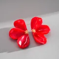 Detailed macro view of vibrant red resin flower stud earrings with golden floral centers - Red