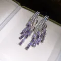 Macro detail view of elegant purple zircon water drop tassel earrings inside a jewelry box - Silver-Purple