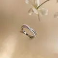 Elegant crossover ring featuring delicate pearls and pavé cubic zirconia accents. - Crisscross Style / Silver