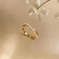 Detailed view of an elegant gold crisscross ring featuring pearls and sparkling zircons - Crisscross Style / Gold