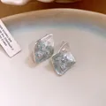 Detail showing unique textured surface and zircon inlays of silver diamond stud earrings - Silver Earring Post - Silver - Blue