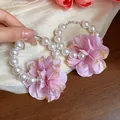Dettaglio ravvicinato di grandi orecchini a cerchio con perle e fiori di stoffa rosa - Stile Tondo con Fiore in Tessuto(HE31885) / Rosa
