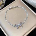 Primo piano di un elegante bracciale in zircone placcato oro 18k con motivo a fiocco - Forma di fiocco