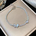 Primo piano di un bracciale in zircone scintillante con farfalla in madreperla e cuore - Ciondolo Farfalla Cuore