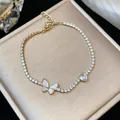 Dettaglio del bracciale placcato oro 18k con zirconi e ciondoli a farfalla e cuore. - Set Farfalla e Cuore