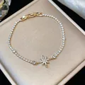 Primo piano di un elegante bracciale tennis placcato oro 18k con ciondolo stella brillante - Catena Tennis Stella