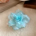 Detailed view of the light blue mesh fabric flower with delicate layered petals - Duckbill Hair Clips / Cyan