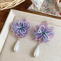 Gros plan sur des boucles d'oreilles fleurs en perles avec perles en goutte. - Violet/Blanc (Tige Argent 925)