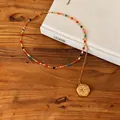 Close-up of double-layered gold necklace with colorful beads and star pendant - Gold-Multicolor